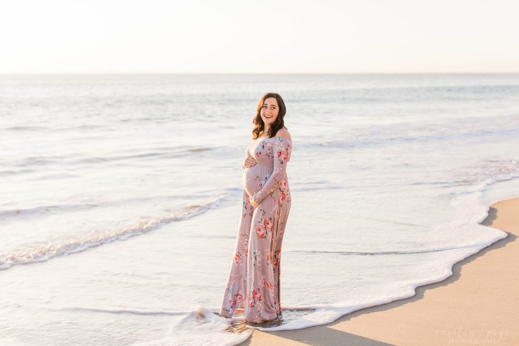 Pregnant woman standing in the ocean on the beach in San Clemente California