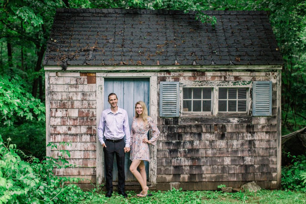 Man and woman standing in front of old shed in the rain