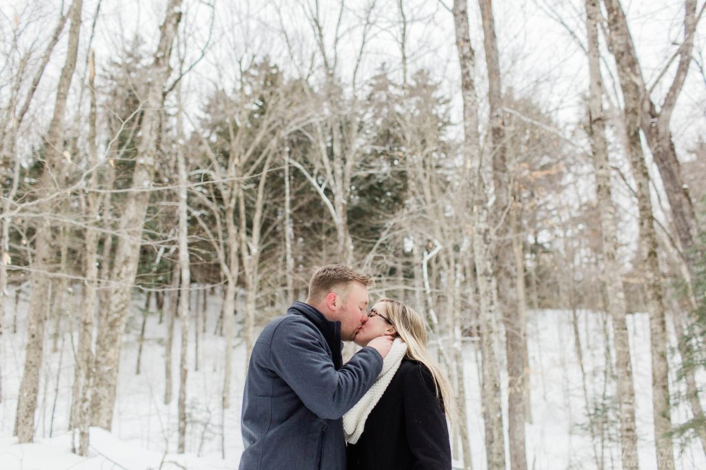 Man and woman kissing in snowy woods