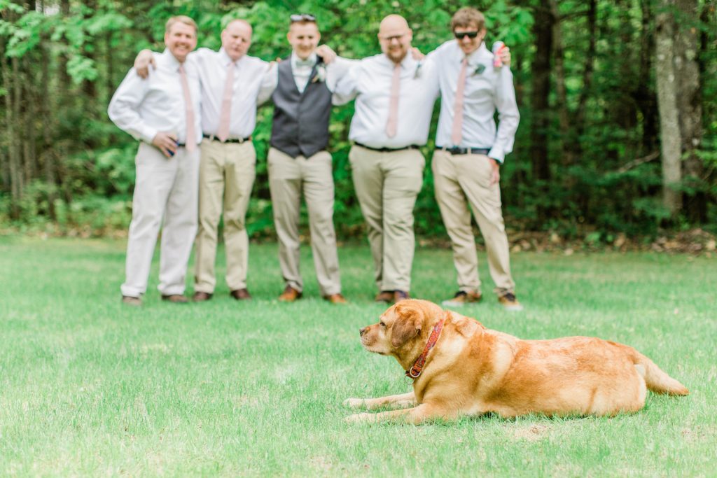 Dog laying in front of groomsmen