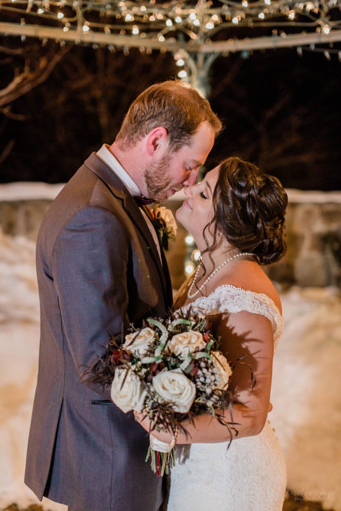 Bride and groom kissing at night with snow