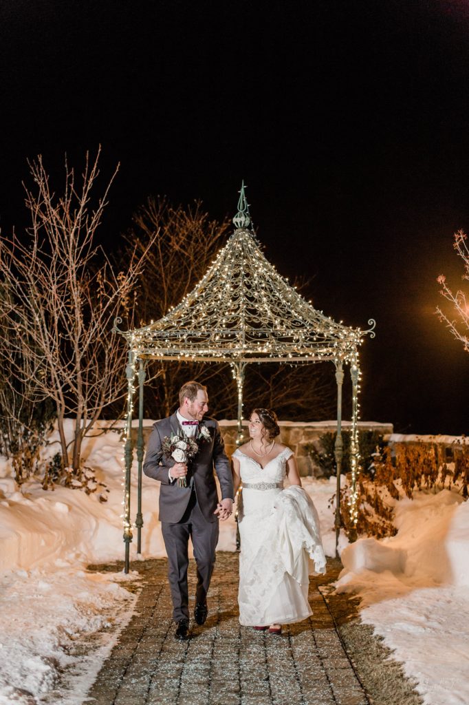 Bride and groom walking in snow at night