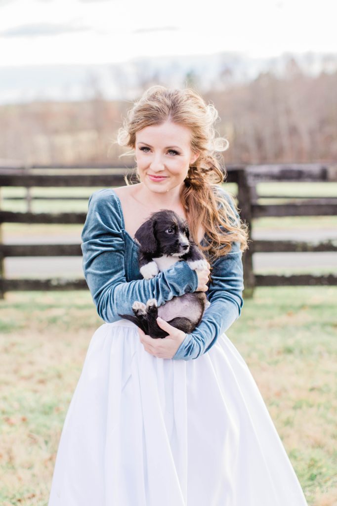 Bride in turquoise bodysuit and white skirt holding puppy at Mount Ida Farm in Charlottesville Virginia