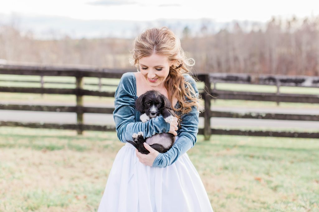 Bride in turquoise bodysuit and white skirt holding puppy at Mount Ida Farm in Charlottesville Virginia