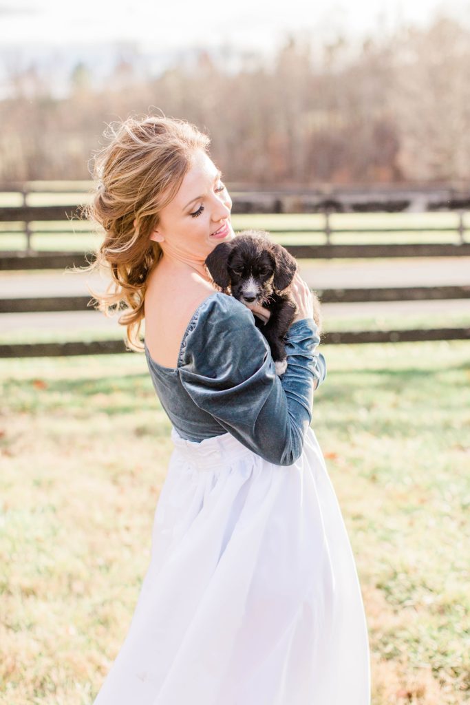 Bride in turquoise bodysuit and white skirt holding puppy at Mount Ida Farm in Charlottesville Virginia