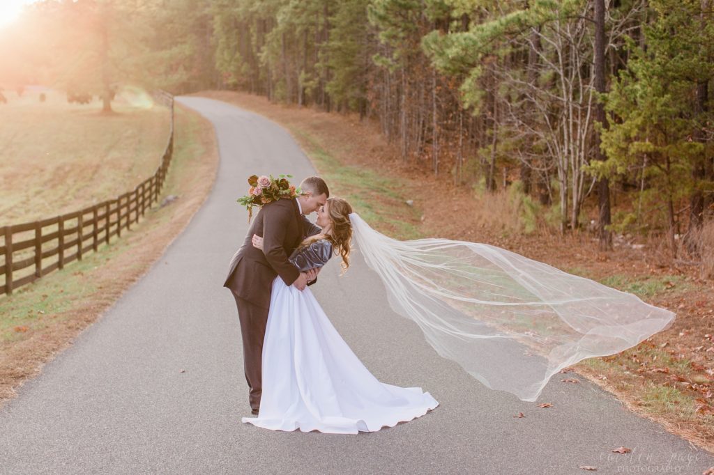 Bride and groom kissing at sunset in front of field of cows at Mount Ida Farm in Charlottesville Virginia