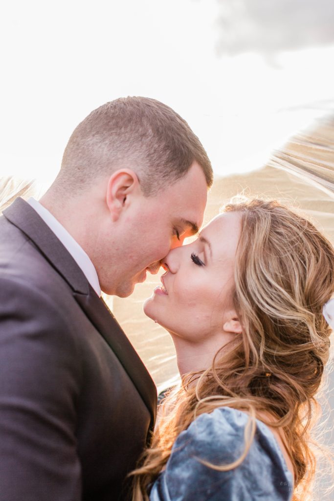 Bride and groom snuggled together under wedding veil at Mount Ida Farm in Charlottesville Virginia