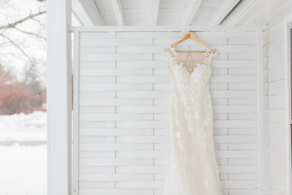 Wedding dress hanging on white lattice wall