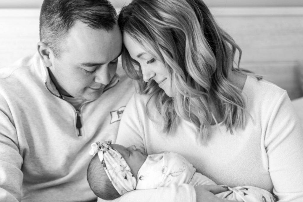 Black and white photo of parents holding newborn baby girl