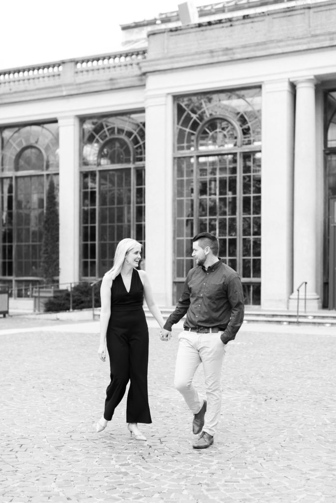 Black and white portrait of man and woman walking outside conservatory at Longwood Gardens