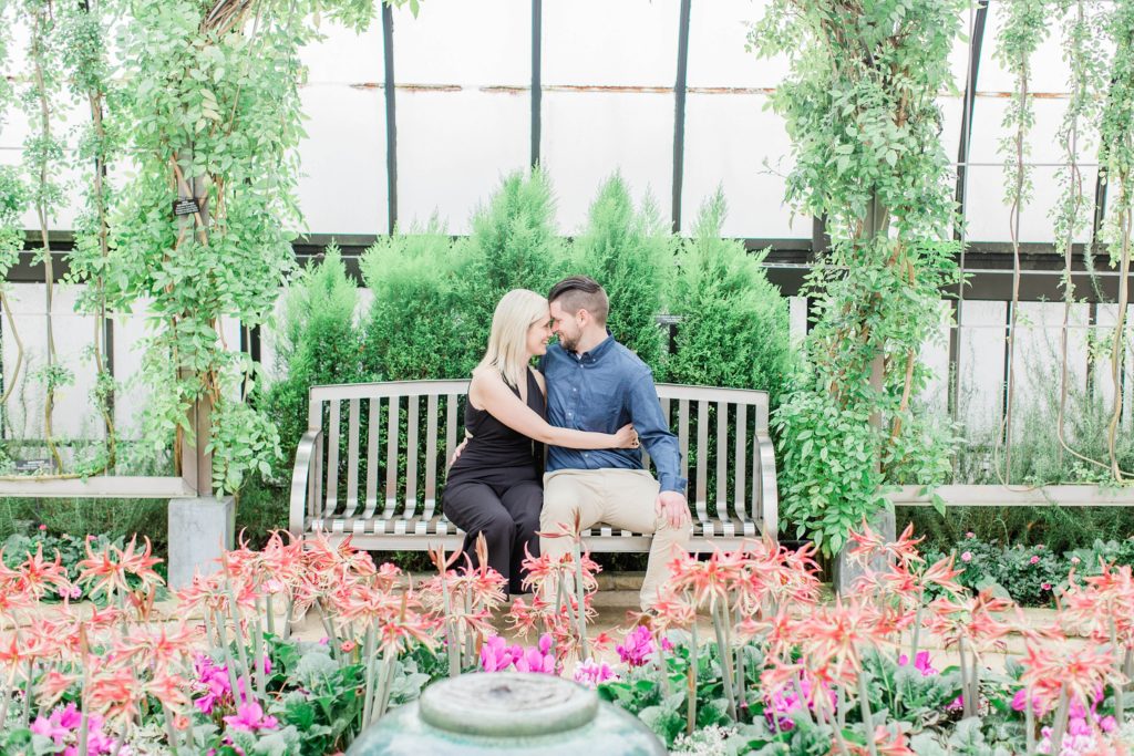 Man and woman sitting on bench in the middle of floral display at Longwood Gardens
