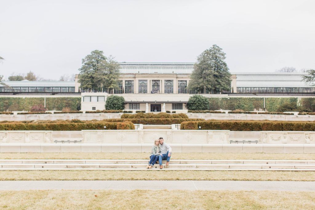 Man and woman sitting on steps on front of conservatory at Longwood Gardens
