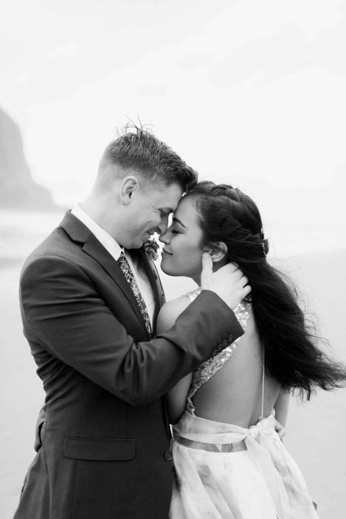 Black and white photo of bride and groom touching their foreheads together