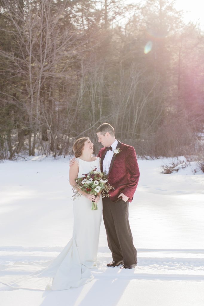 Wedding couple looking at each other on frozen Lake Winnipesaukee in Wolfeboro New Hampshire