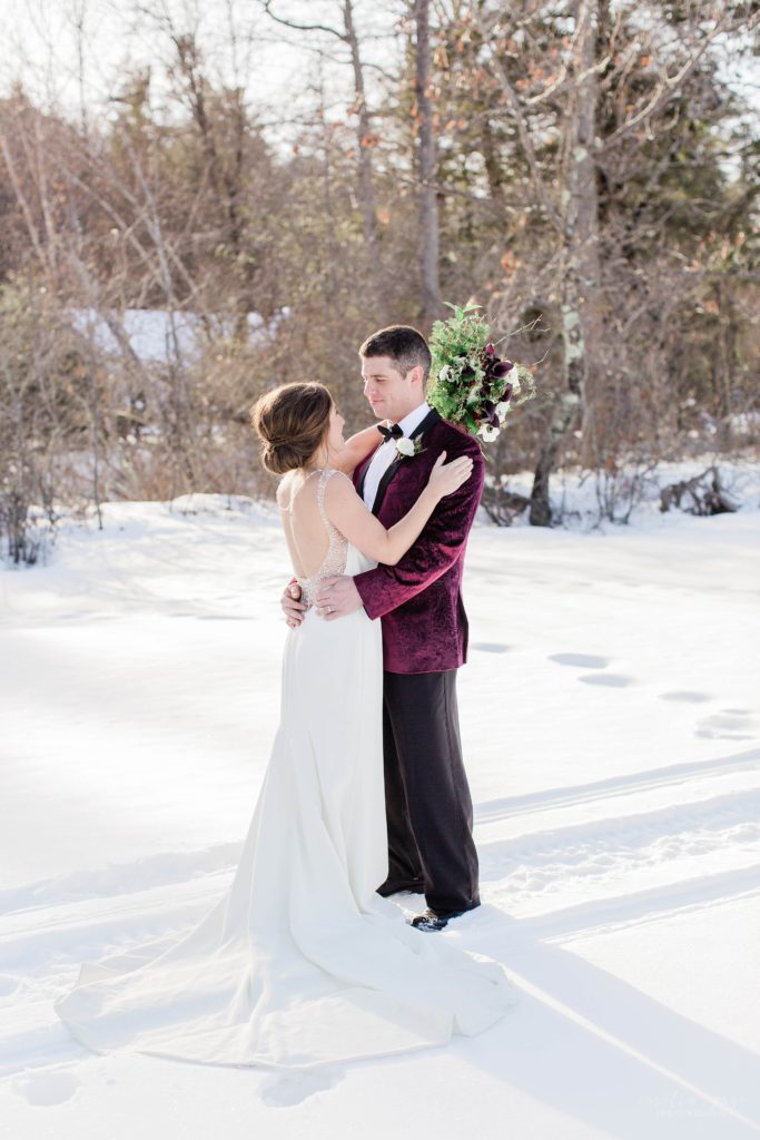 Wedding couple standing together on frozen Lake Winnipesaukee in Wolfeboro New Hampshire