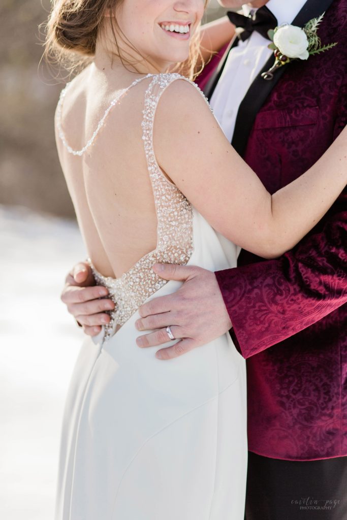 Groom holding bride in backless dress