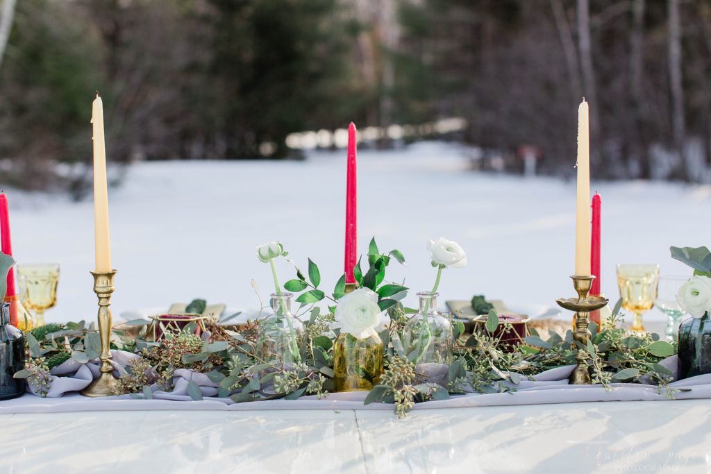 Greenery and candle centerpiece on styled wedding reception table
