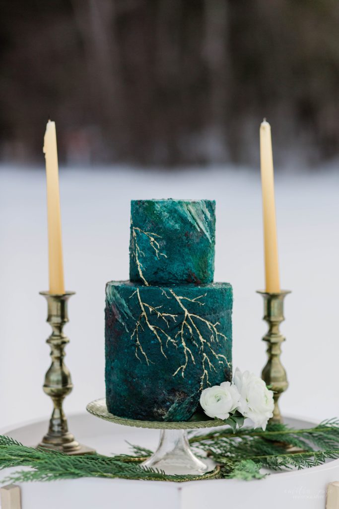 Deep turquoise cake with gold details and candles