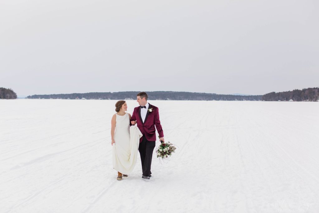 Bride and groom walking together in middle of frozen lake