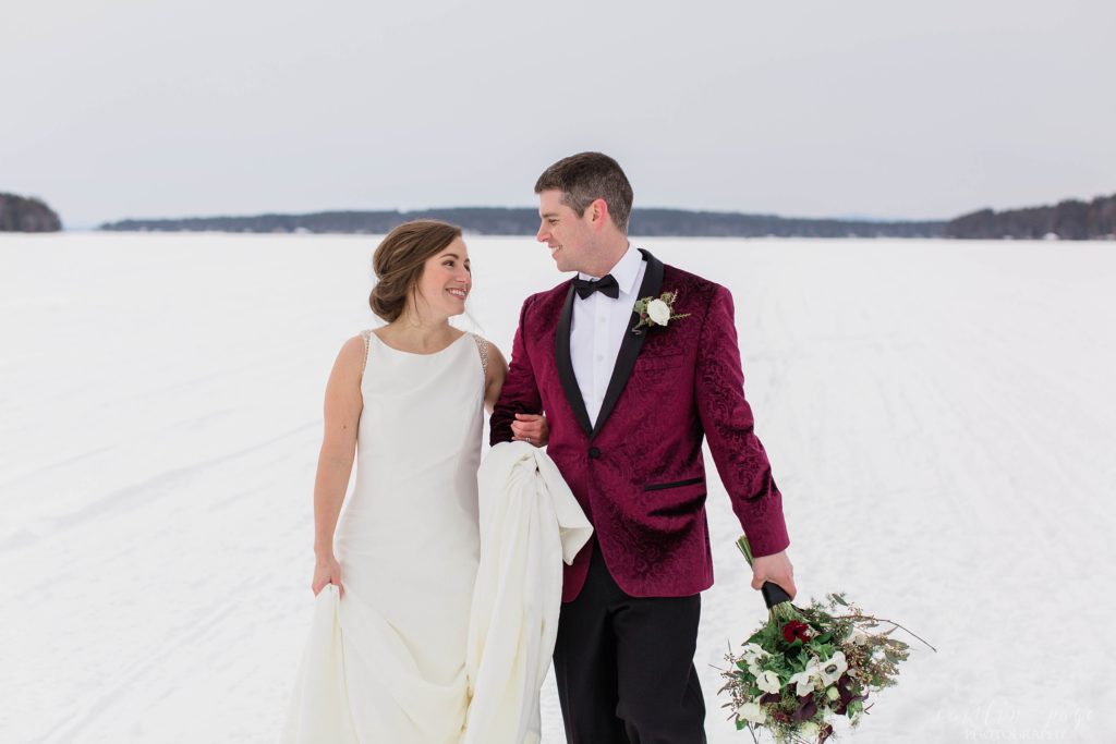 Bride and groom walking together in middle of frozen lake