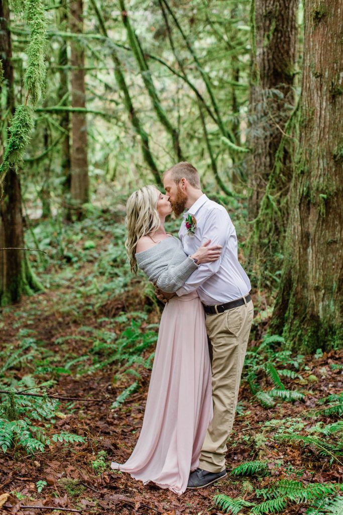 Man and woman kissing in the forest at romantic elopement