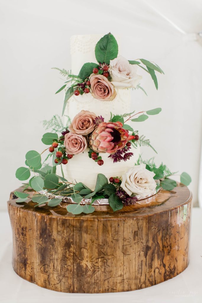 White wedding cake with proteas and greens