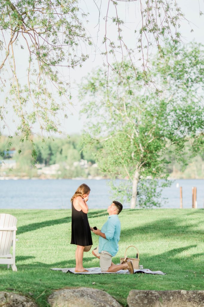 Man proposing to woman in front of lake