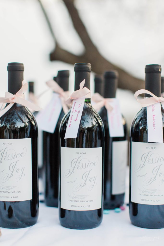 Bottles of wine with labels on them with bride and grooms names