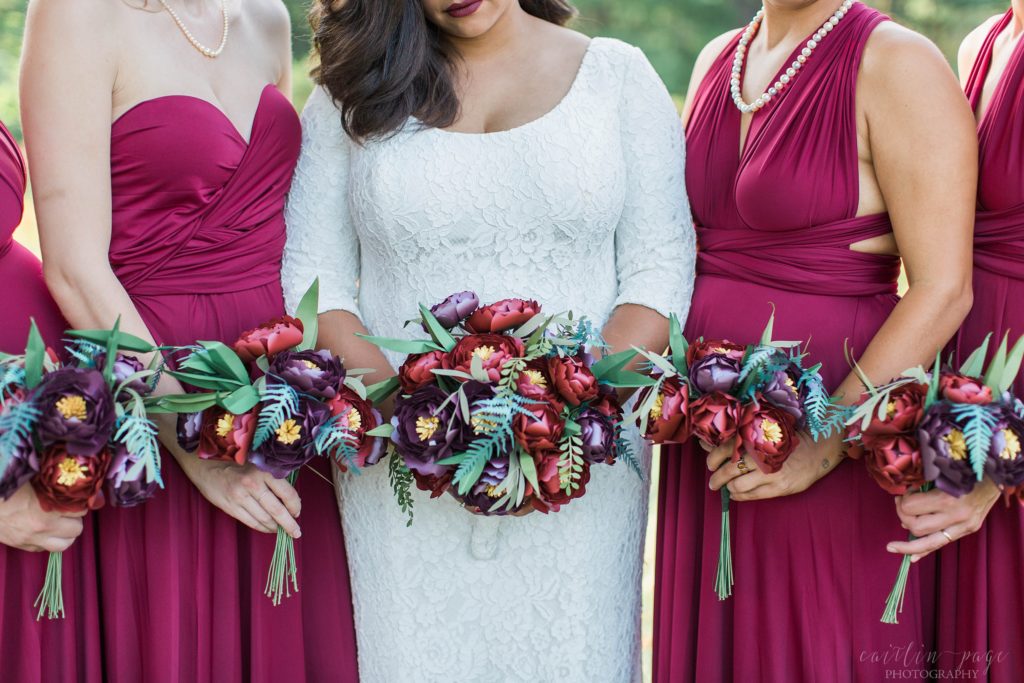 Bride and bridesmaids holding onto paper flower bouquets