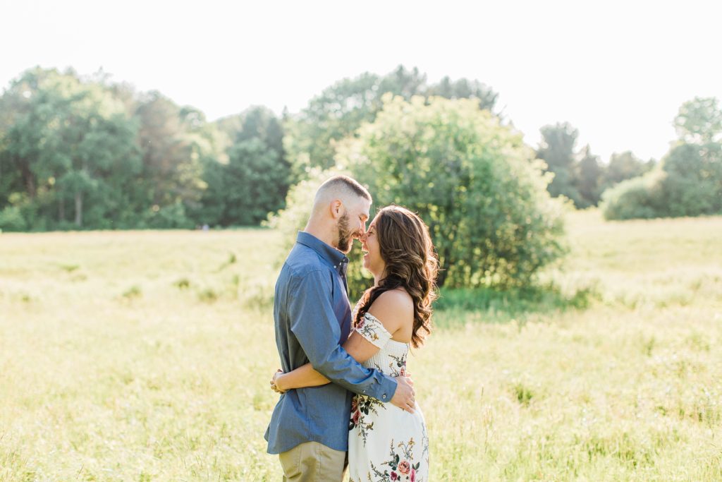 Man and woman nuzzling nose to nose in field