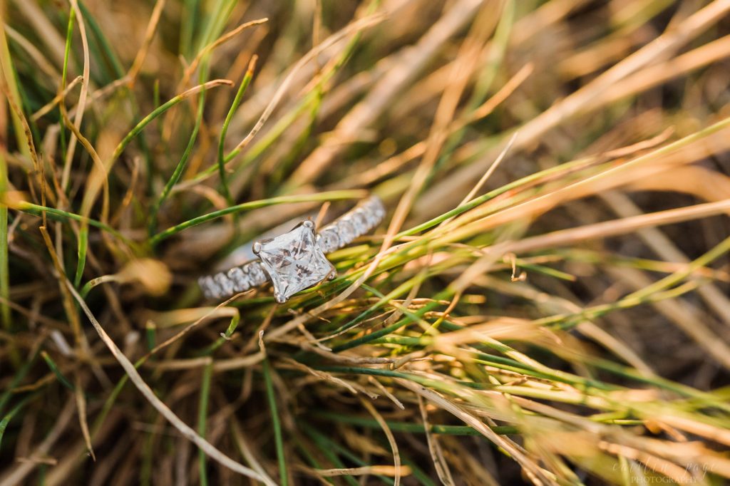 Square solitaire diamond engagement ring in grass