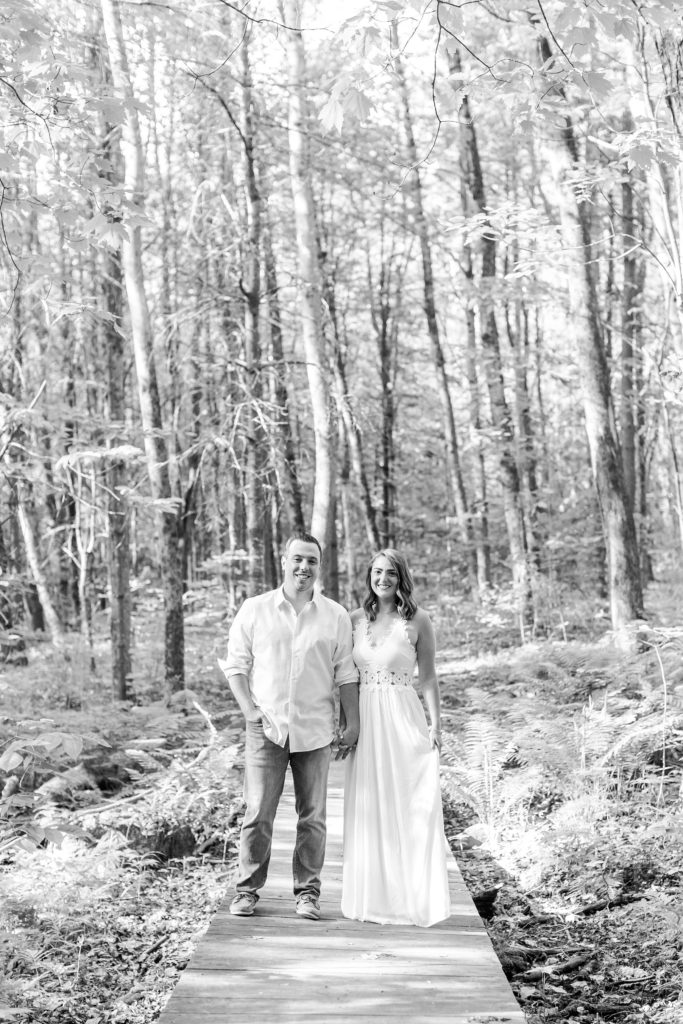 Black and white photo of man and woman standing in the woods