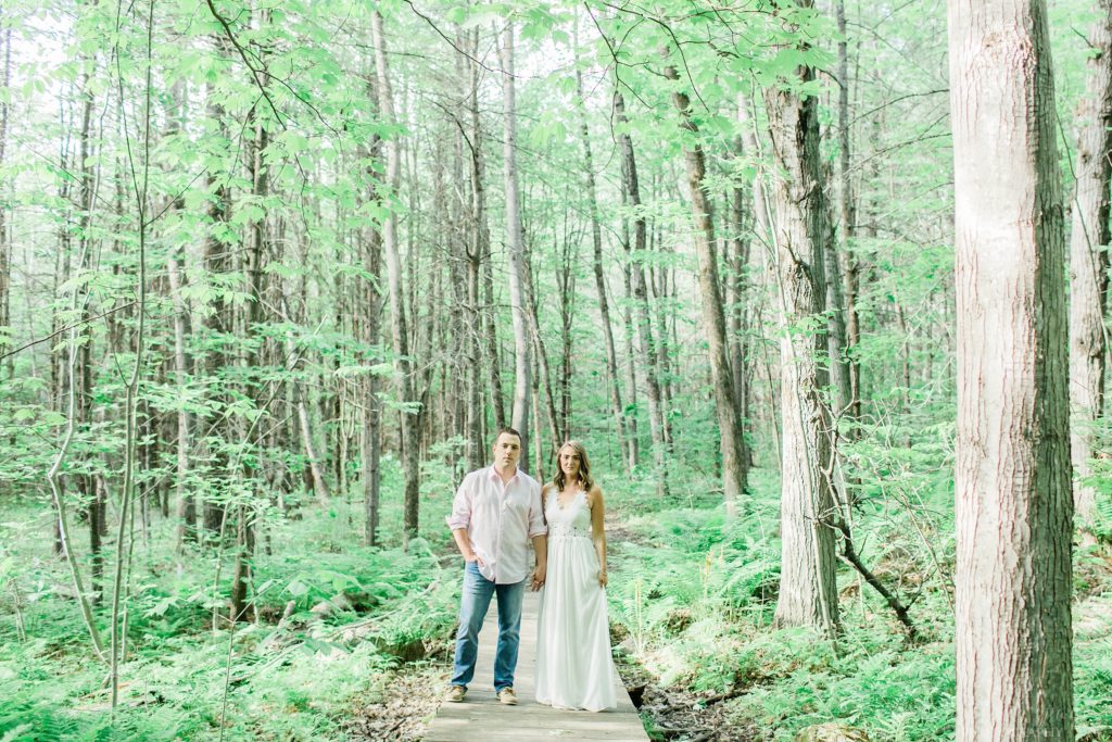 Man and woman standing on bridge in the woods