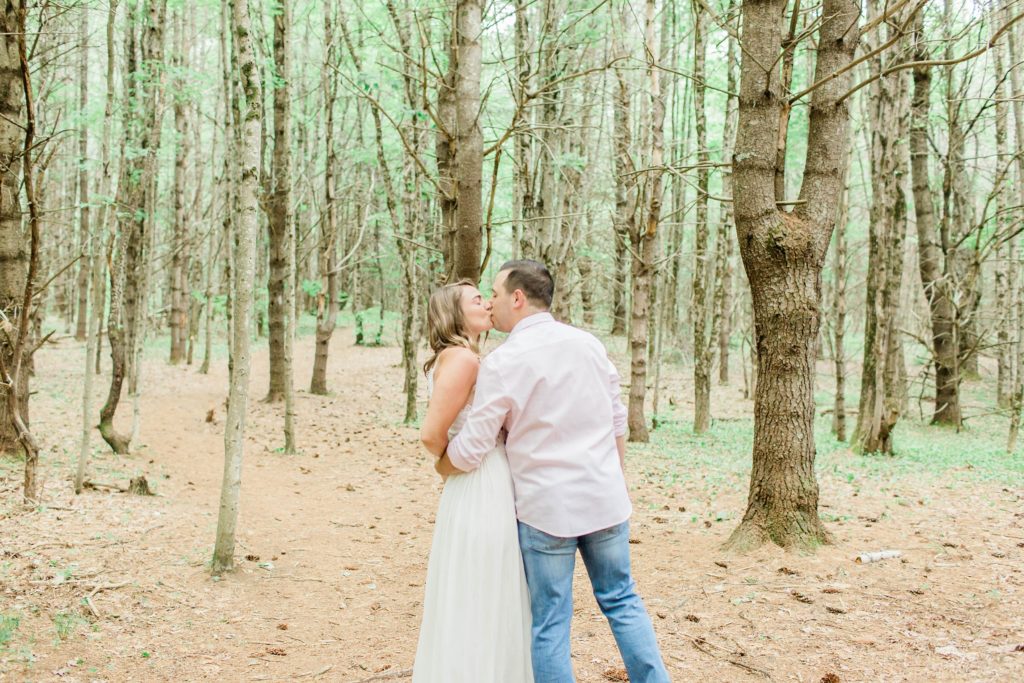 Man and woman kissing in the woods