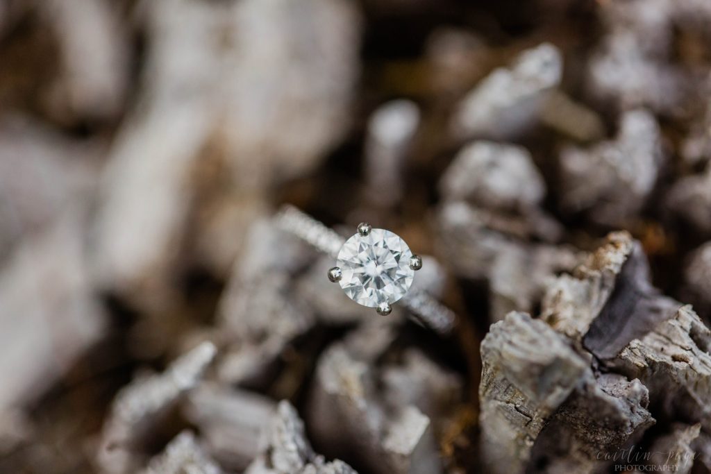 Solitaire engagement ring on a piece of wood