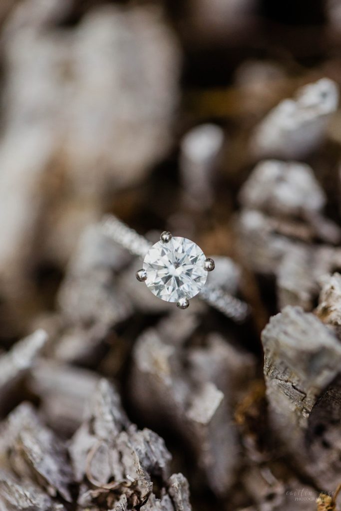 Solitaire engagement ring on a piece of wood