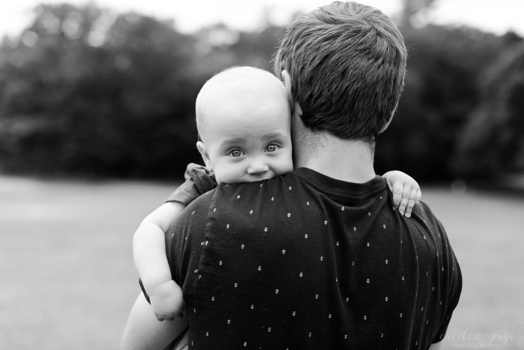 Black and white photo of little boy being held by dad