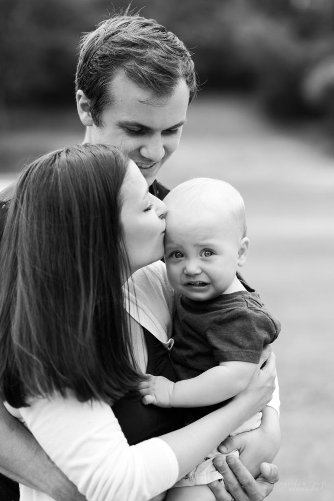 Black and white photo of parents holding toddler boy