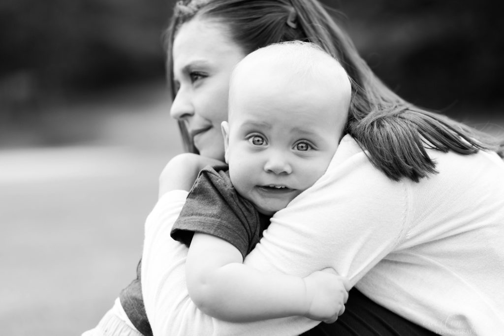 Black and white photo of toddler boy hugging his mom