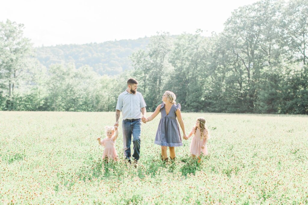 Young family walking through a field together