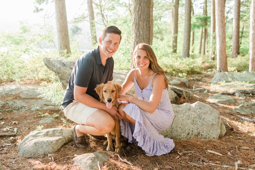 Man and woman crouched down with golden retriever puppy