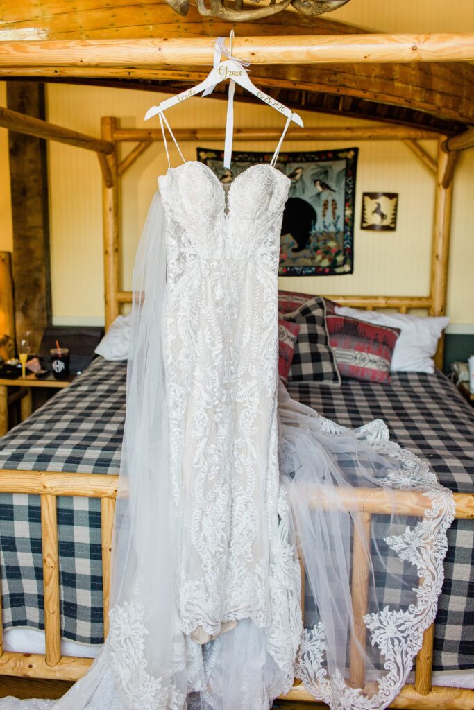 Lace Martina Liana wedding dress hanging on bed