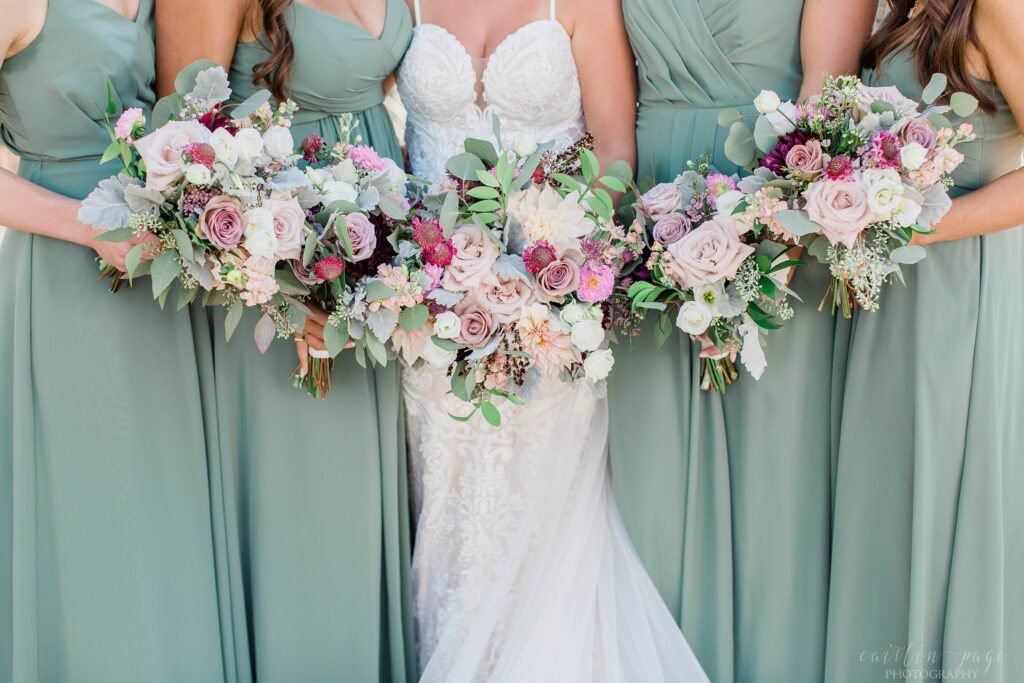 Bride and bridesmaids in sage dresses holding wedding bouquets