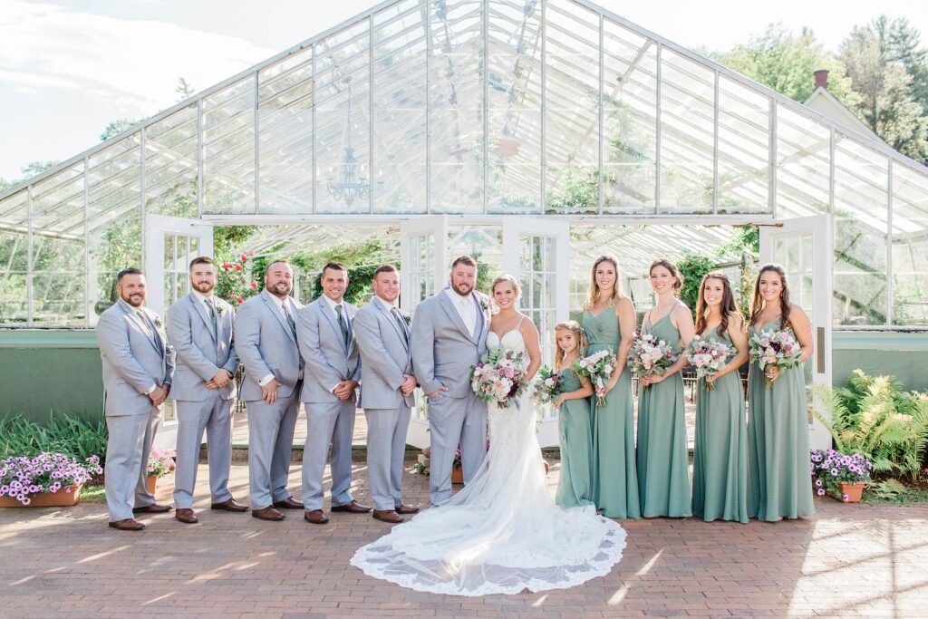 Bridal party standing in front of greenhouse at Barn on the Pemi