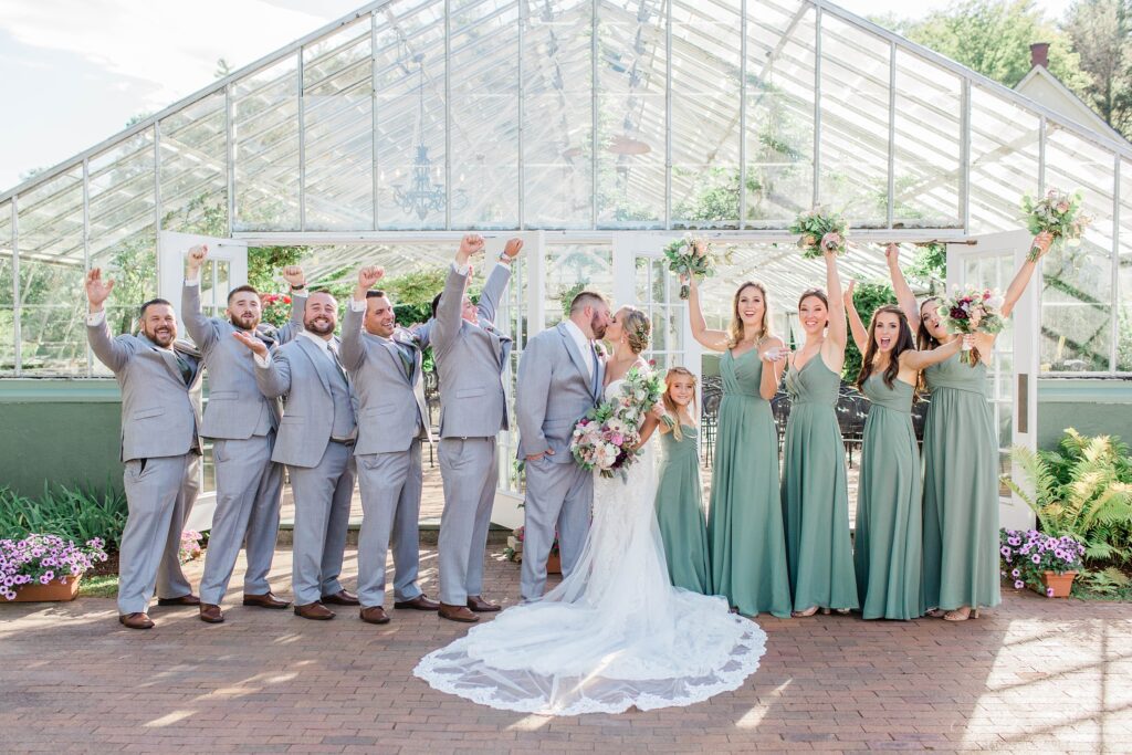 Bridal party standing in front of greenhouse at Barn on the Pemi