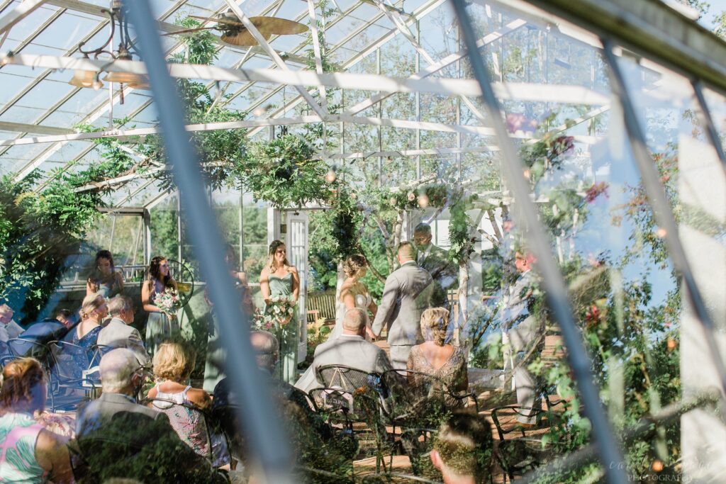 Bride and groom standing at the altar together inside greenhouse