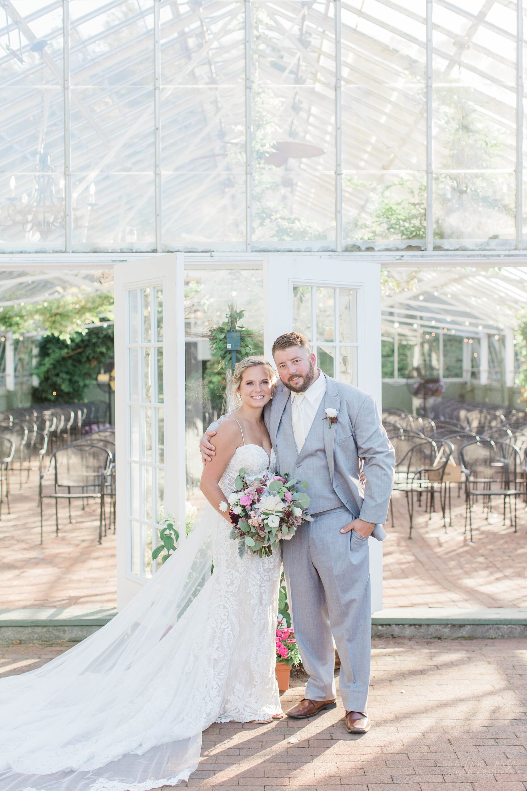 Bride and groom standing outside the greenhouse at the Barn on the Pemi