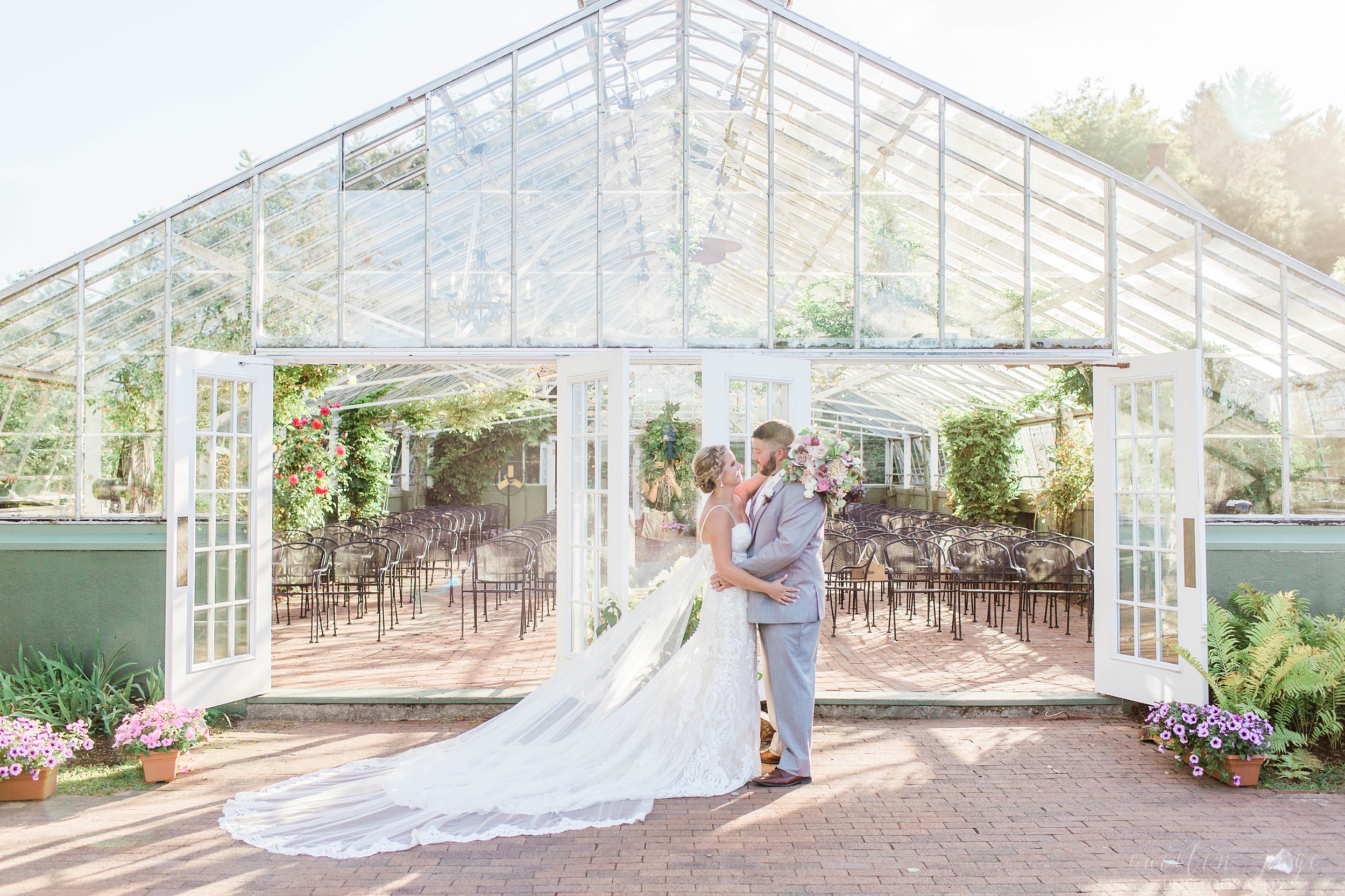 Bride and groom standing outside the greenhouse at the Barn on the Pemi