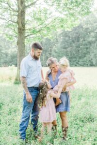 Young family standing under a tree in a field