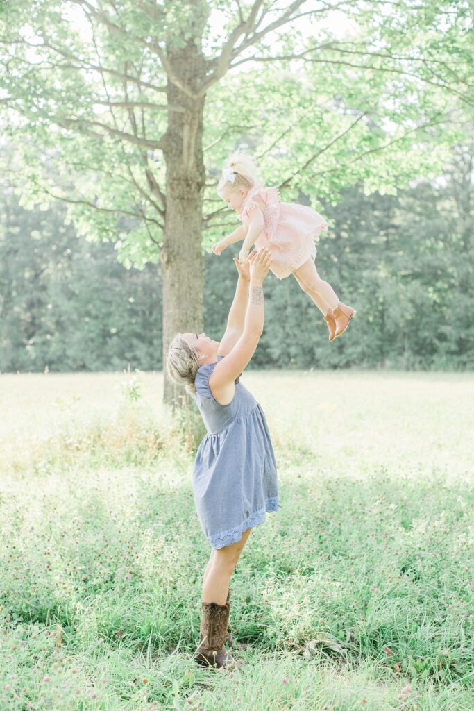 Mom throwing little girl in the air